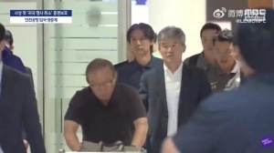 凌晨四点抵达韩国的洪明甫教练，依然躲不过球迷的怒吼声。配图